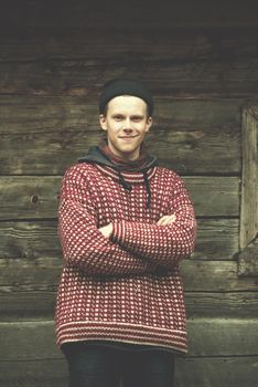 portrait of young hipster,  man with nose piercing  in front of old vintage wooden house