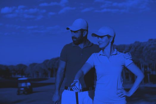 portrait of happy young  couple on golf course duo tone