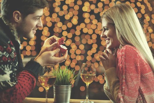 The young man gives a wedding ring   gift to  girl in restaurant