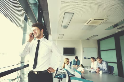 Portrait of a handsome young  business man  on a meeting in offce with colleagues in background