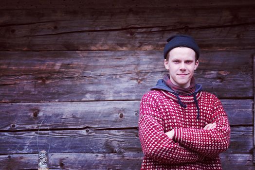 portrait of young hipster,  man with nose piercing  in front of old vintage wooden house