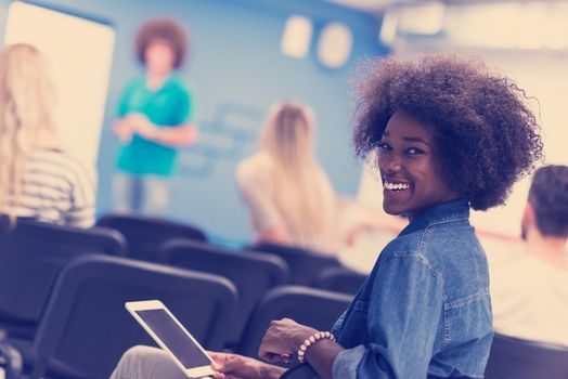 portrait of young African American business woman at modern startup office interior, team in meeting in background