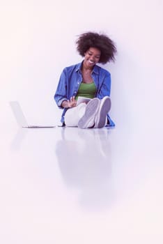 Portrait of happy young african american woman sitting on floor with laptop