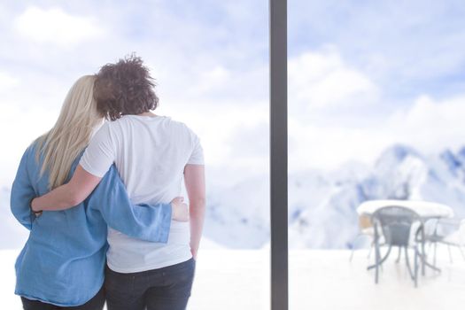 romantic happy young couple enjoying morning coffee by the window on cold winter day at home