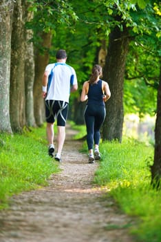 Young couple jogging in park at morning. Health and fitness.