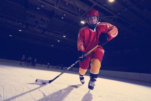 teen girl children ice hockey player in action kicking puck with stick