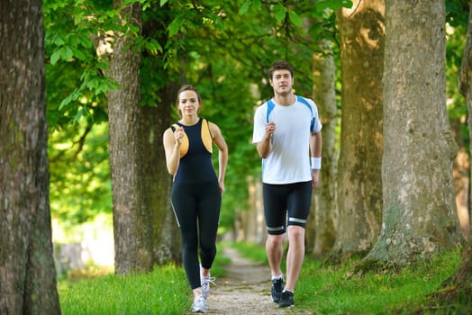 Young couple jogging in park at morning. Health and fitness.