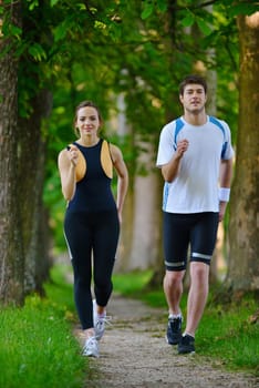 Young couple jogging in park at morning. Health and fitness.