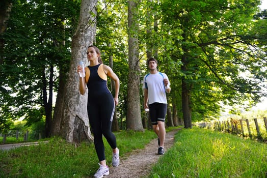 Young couple jogging in park at morning. Health and fitness.