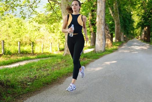 Young beautiful  woman jogging on morning at  park. Woman in sport outdoors health concept