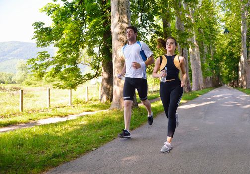 Young couple jogging in park at morning. Health and fitness.