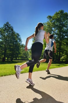 Young couple jogging in park at morning. Health and fitness.