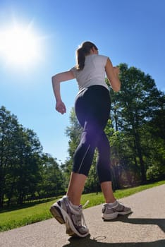 Young beautiful  woman jogging on morning at  park. Woman in sport outdoors health concept