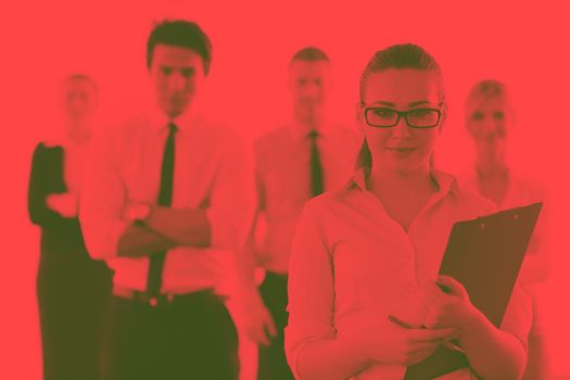 Successful business woman standing with her staff in background at modern bright office