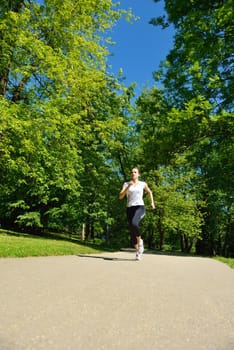 Young beautiful  woman jogging on morning at  park. Woman in sport outdoors health concept