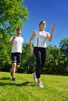 Young couple jogging in park at morning. Health and fitness.