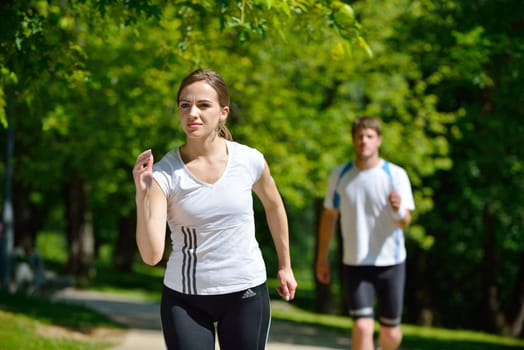 Young couple jogging in park at morning. Health and fitness.