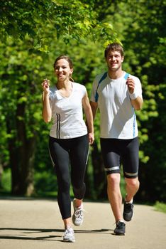 Young couple jogging in park at morning. Health and fitness.