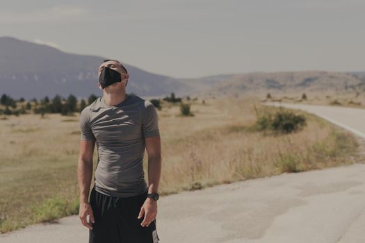 Young man and woman in protective masks running and doing exercises outdoors in the morning. Sport, Active life, Jogging during quarantine. Covid-19 new normal. High quality photo. Selective focus.