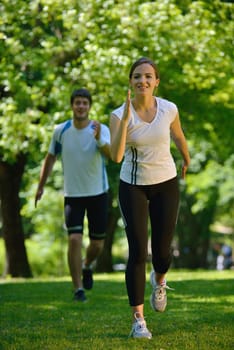 Young couple jogging in park at morning. Health and fitness.