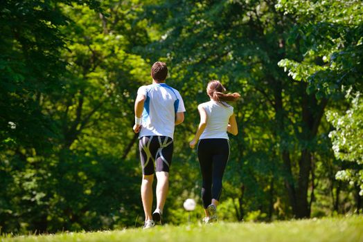 Young couple jogging in park at morning. Health and fitness.