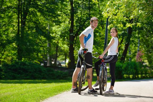 Happy couple riding bicycle outdoors, health lifestyle fun love romance concept