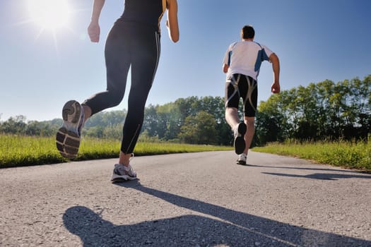 Young couple jogging in park at morning. Health and fitness.