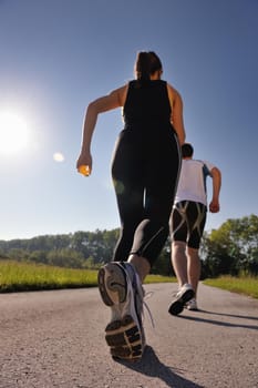 Young couple jogging in park at morning. Health and fitness.