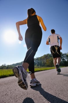 Young couple jogging in park at morning. Health and fitness.