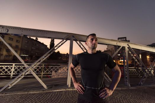 urban sports, young healthy man jogging across the bridge in the city at early morning in night