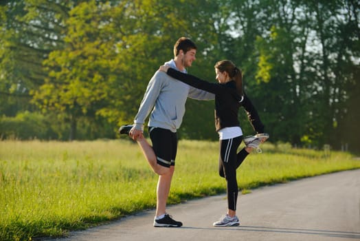 young health couple doing stretching exercise relaxing and warm up after jogging and running in park