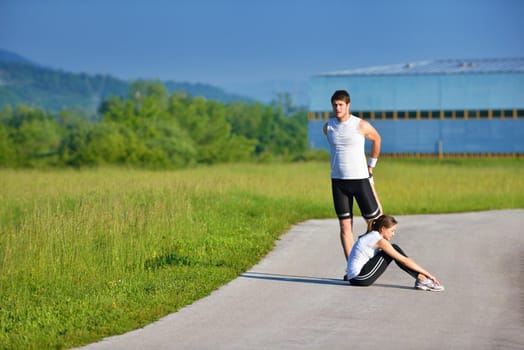 young health couple doing stretching exercise relaxing and warm up after jogging and running in park