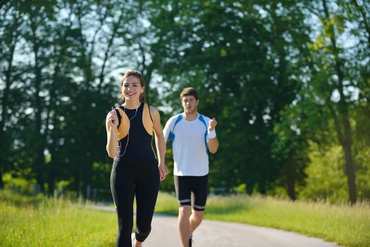 Young couple jogging in park at morning. Health and fitness concept