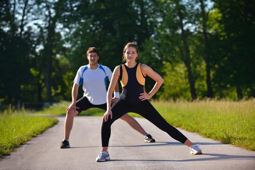 young health couple doing stretching exercise relaxing and warm up after jogging and running in park