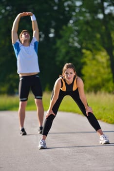 young health couple doing stretching exercise relaxing and warm up after jogging and running in park