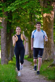 Young couple jogging in park at morning. Health and fitness.