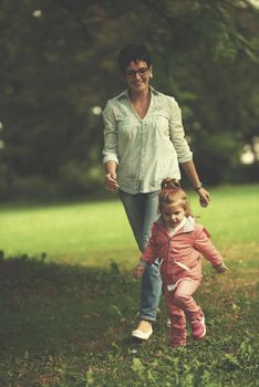 happy family playing together outdoor  in park mother with kids  running on grass