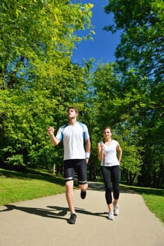 Young couple jogging in park at morning. Health and fitness.