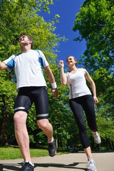 Young couple jogging in park at morning. Health and fitness.