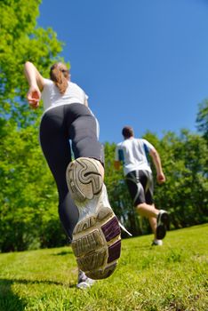 Young couple jogging in park at morning. Health and fitness.