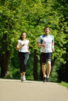 Young couple jogging in park at morning. Health and fitness.