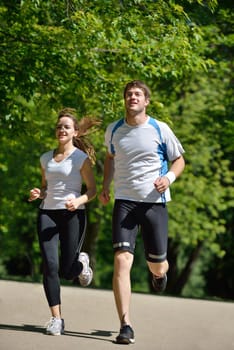 Young couple jogging in park at morning. Health and fitness.