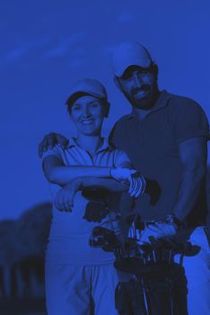 portrait of happy young  couple on golf course duo tone