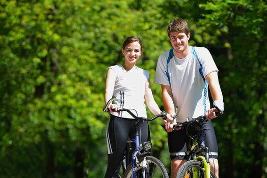 Happy couple riding bicycle outdoors, health lifestyle fun love romance concept