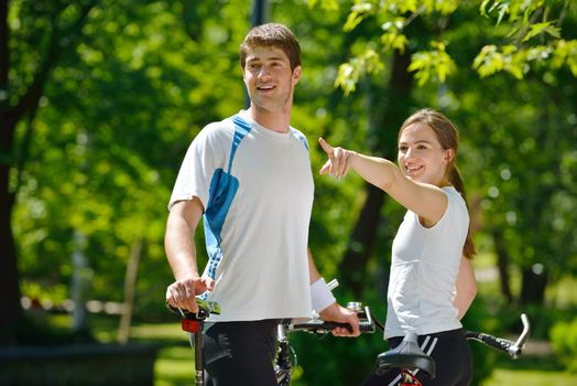 Happy couple riding bicycle outdoors, health lifestyle fun love romance concept