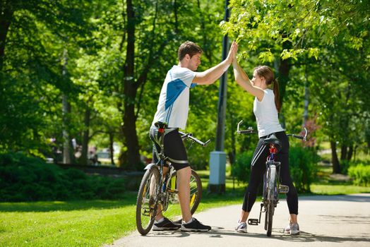 Happy couple riding bicycle outdoors, health lifestyle fun love romance concept