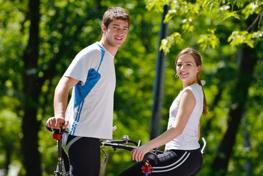 Happy couple riding bicycle outdoors, health lifestyle fun love romance concept