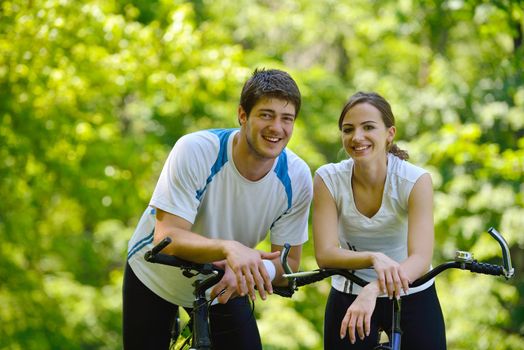 Happy couple riding bicycle outdoors, health lifestyle fun love romance concept