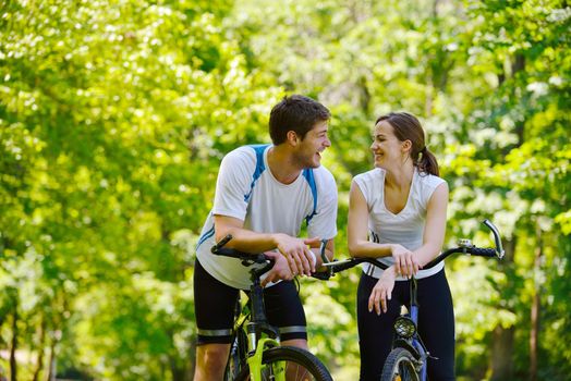 Happy couple riding bicycle outdoors, health lifestyle fun love romance concept