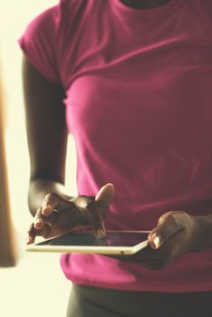 beautiful african american woman using tablet computer from home while rain and bad weather is outdoor